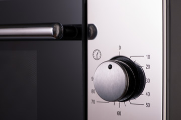 thermostat and handles on a modern microwave, close-up. kitchen equipment