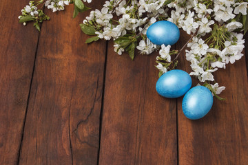 Cherry Blossom Branch and Easter Eggs on a Wooden Background.