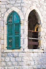 Old arch window with green shutters in an abandoned building, Windows with green shutters in Oriental style