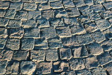 A texture of grey cobbled street as background
