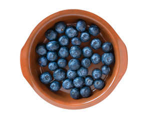 blueberries in a clay plate isolated on a white background. juicy fresh bilberry. top view closeup