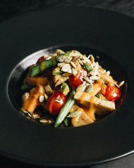 Fresh healthy dinner with seeds and vegetables on black plate