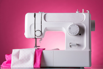 Multifunctional sewing machine, fabric under presser, on pink