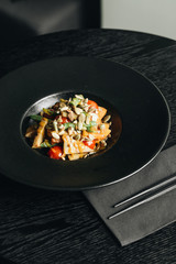 Fresh healthy dinner with seeds and vegetables on black plate