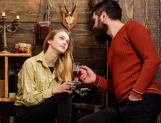 Couple spend cozy pleasant evening with hot drinks. Man and lady talking while hold glass or mug with mulled wine. Couple in love talking in romantic atmosphere, wooden background. Romantic concept