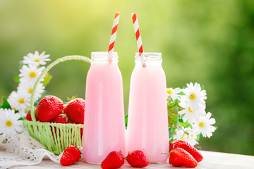 Strawberry cocktail or milkshake in a jar, basket with strawberries on a picnic, healthy food for Breakfast and snacks. Selective focus.