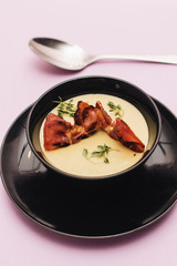 Delicious cream soup in black bowl