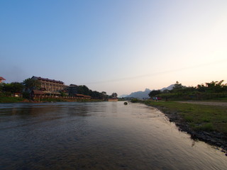 Fototapeta premium Sunset at Riverside with mountain background , Travel in Vang Viang City, Laos. 5th December, 2013.