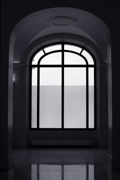 Big window and arched hallway. Black and white.