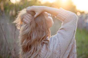 Cute charming girl in summer in the field. Young woman is happy and feels free outdoors