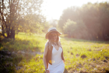 Cute charming girl in summer in the field. Young woman is happy and feels free outdoors