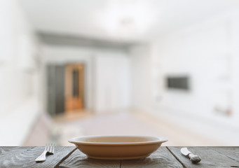 empty plate with fork and knife on wooden table