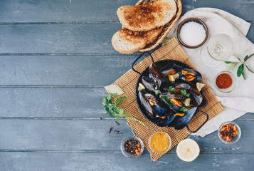 Delicious seafood fresh mussels with spices on wooden table. Top view, copy space