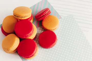 stylish red and yellow macaroons stacked on modern craft paper, creative view. space for text. catering for celebrations and holidays concept