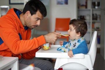 Bambino che mangia con il papà