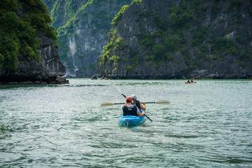 Tourists paddling kayak on Halong bay in Vietnam, UNESCO World Heritage Site