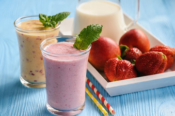 Strawberry and peach milkshakes on blue background.