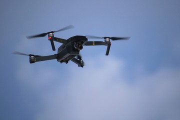 Close up of flying unmaned aerial vehicle against blue sky