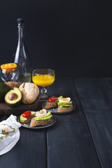 Tasty and juice , sandwich with avocado, tomato and poached egg on wooden chopping board, close up, selective focus. Healthy delicious breakfast or lunch. On a dark background, top view. text
