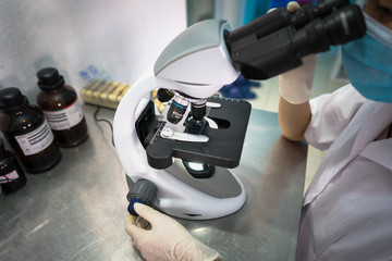 Fototapeta na wymiar Asian technician tests the quality of product in laboratory closeup
