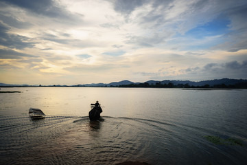 Naklejka na ściany i meble Vietnam landscape. Lake with elephant walking at sunset in Vietnam
