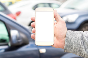 Man holding smartphone with empty blank white screen. Many cars or traffic in background. Mobile phone in hand. Template for navigation, parking or ride share app. Transportation smart application.