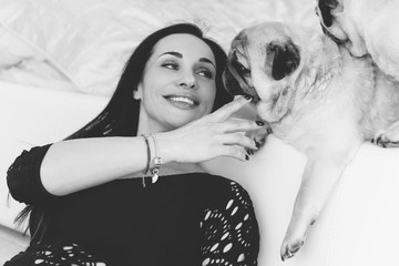 Nice woman with cute pug dog at home. Pet adoption, life of pets. Female carrying a pug, animals healthy happy canine adorable breed  