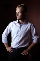 portrait of young successful businessman on dark background