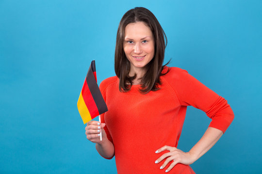 Beautiful brunette woman with the flag of Germany on a blue background.