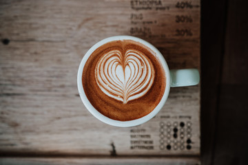 Top view latte art coffee on wooden table.Close up with copy space.Close up