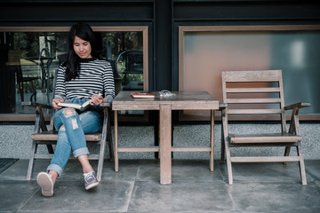 Hipster woman teenager sitting enjoy reading book at cafe.