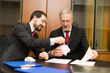Man putting money in a piggy bank