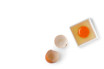 Fresh raw egg. Egg yolk and white in small bowl with broken shell  beside ,isolated white background top view and copy space.
