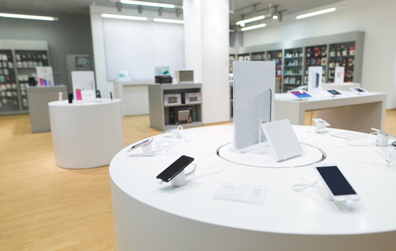 Showcase with smartphones in a light electronics store. Technology store with light modern interior
