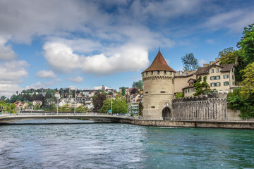Fototapeta na wymiar An old European city of Lucerne. Dam with waterfalls on a mountain lake.