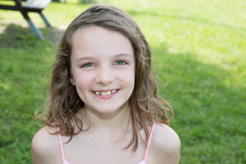 The happy little girl in the green grass