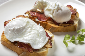 Two poached eggs with bacon on toast cooked breakfast