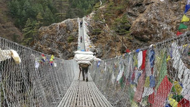 Largest suspension bridge in Solu Khumbu valley with colorful prayer flags, trekking area to the base camp of Everest peak (8848 m).