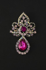 Brooch with pink diamonds isolated on black