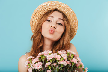 Cute caucasian woman holding flowers blowing kisses.