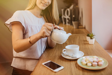 Beautiful young woman is drinking tea in a cafe, the morning.