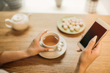 Close up of women's hands holding cell telephone .
