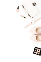 Fashion blogger workspace flat lay with pumps, cosmetics, purse, planner book and flowers.