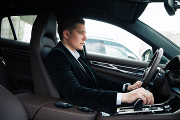 Professionals go only forward! Side view portrait of the handsome confident young entrepreneur carefully driving the automobile.
