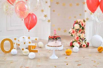 One year decoration idea. A lot of balloons red and white colors. Beautiful cake for birthday party. 