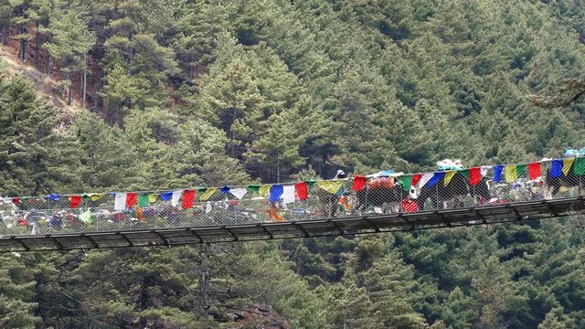 Largest suspension bridge in Solu Khumbu valley with colorful prayer flags, trekking area to the base camp of Everest peak (8848 m).