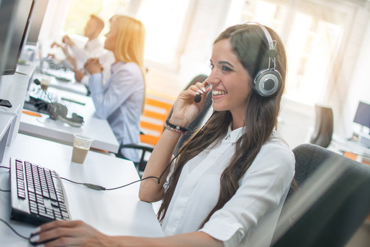 Customer service operator woman with headset working on computer at office
