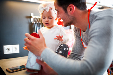 Little child girl in the kitchen having fun with her dad, family lifestyle