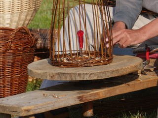 Detail of basket maker at work, A wicker basket, on a round work table, with one hand which braids,...
