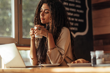 Freelancer woman sitting at a cafe with her laptop computer